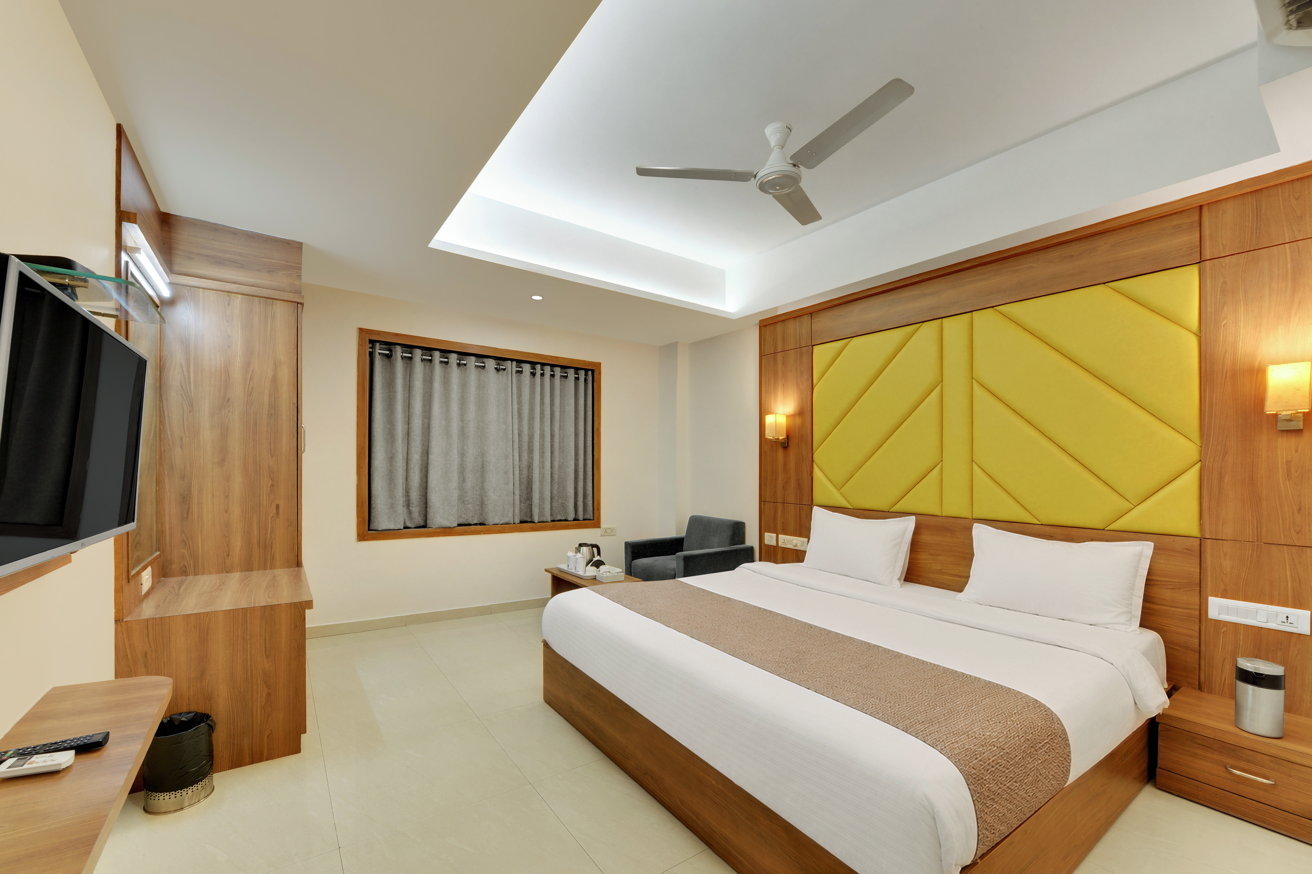 Hotel Shital Inn Deluxe Double Bed Room with upholstered headboard and window